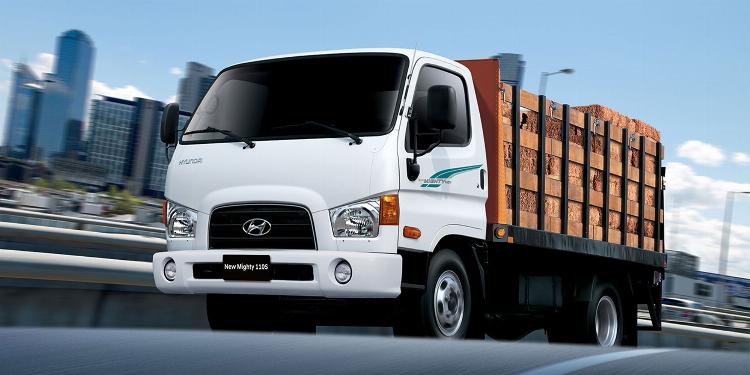 Cận cảnh khối động cơ diesel hiện đại của một chiếc xe tải 10 tấn, các chi tiết máy móc sáng bóng, thể hiện sự mạnh mẽ và công nghệ tiên tiến.