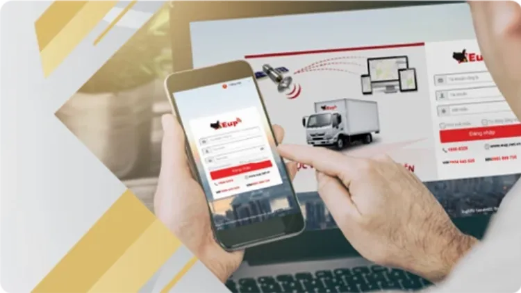 Màn hình máy tính hiển thị giao diện phần mềm quản lý đội xe tải với bản đồ và vị trí các xe theo thời gian thực