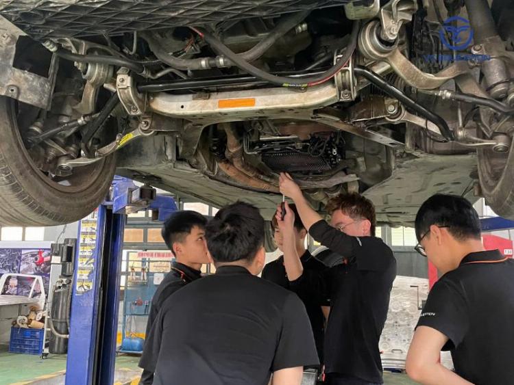 Một kỹ thuật viên chuyên nghiệp đang kiểm tra kỹ lưỡng phần khung gầm chassis của xe tải để phát hiện hư hỏng