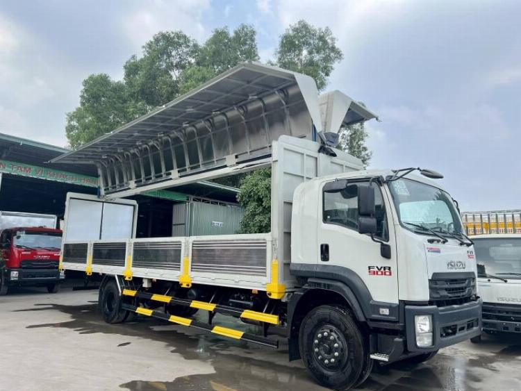 Hình ảnh một chiếc xe tải 12 tấn Hino màu trắng hiện đại đang di chuyển trên đường quốc lộ trong điều kiện ánh sáng ban ngày